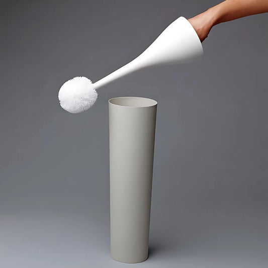 A white toilet brush with a sleek handle being placed into a cylindrical holder against a grey background.