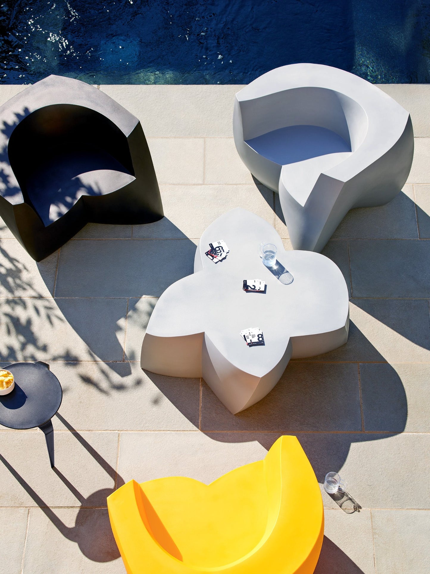 Three sculptural Frank Gehry Easy Chairs, A Frank Gehry Coffee Table and a Tavollini by the pool.